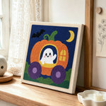 Ghost in pumpkin carriage punch needle artwork displayed on a table