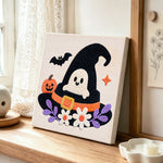 Ghost in witch hat punch needle artwork displayed on a table
