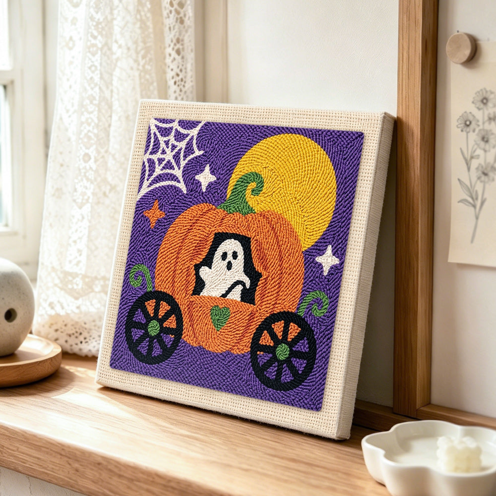 Ghost inside pumpkin carriage punch needle artwork displayed on a table