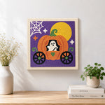 Finished ghost inside pumpkin carriage artwork displayed on a wall