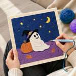 Creating handmade ghost leaning on pumpkin punch needle artwork
