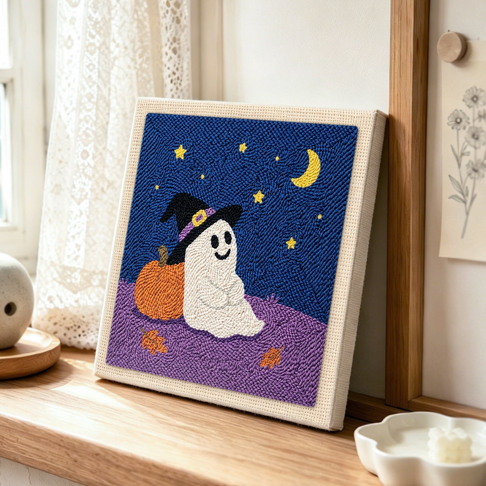 Ghost leaning on pumpkin punch needle artwork displayed on a table