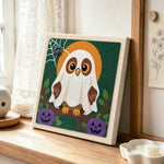 Ghost‑owl with pumpkins punch needle artwork displayed on a table
