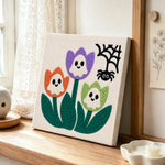 Ghost tulip blooms punch needle artwork displayed on a table