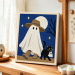 Ghost walking with cat punch needle artwork displayed on a table