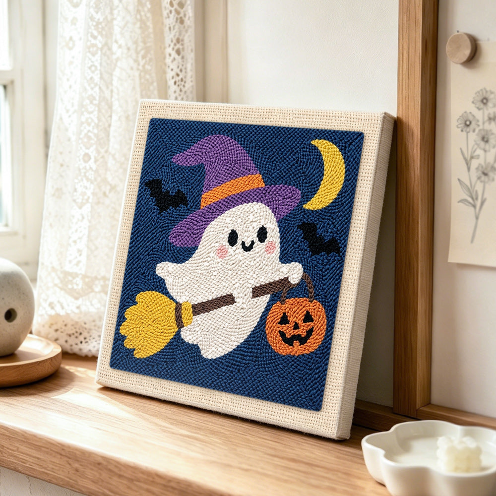Ghost witch on broom punch needle artwork displayed on a table