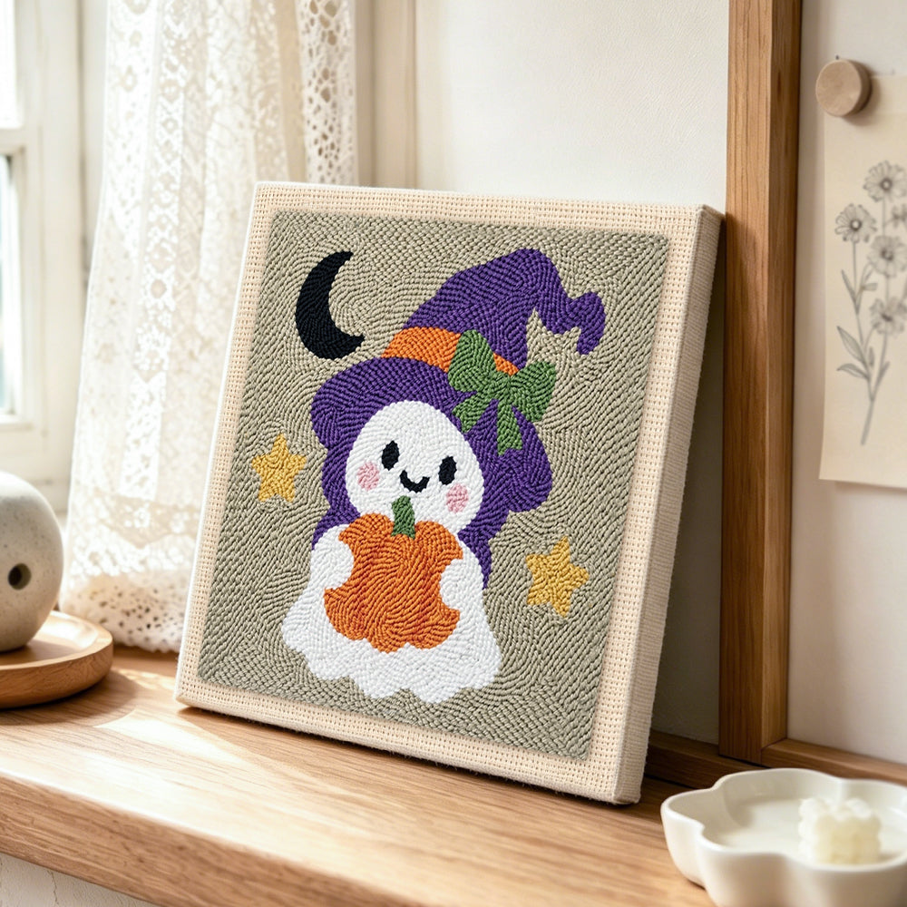 Ghost witch with pumpkin lantern punch needle artwork displayed on a table