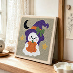 Ghost witch with pumpkin lantern punch needle artwork displayed on a table