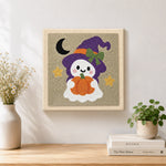 Finished ghost witch with pumpkin lantern artwork displayed on a wall