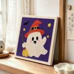 Ghost with broom punch needle artwork displayed on a table