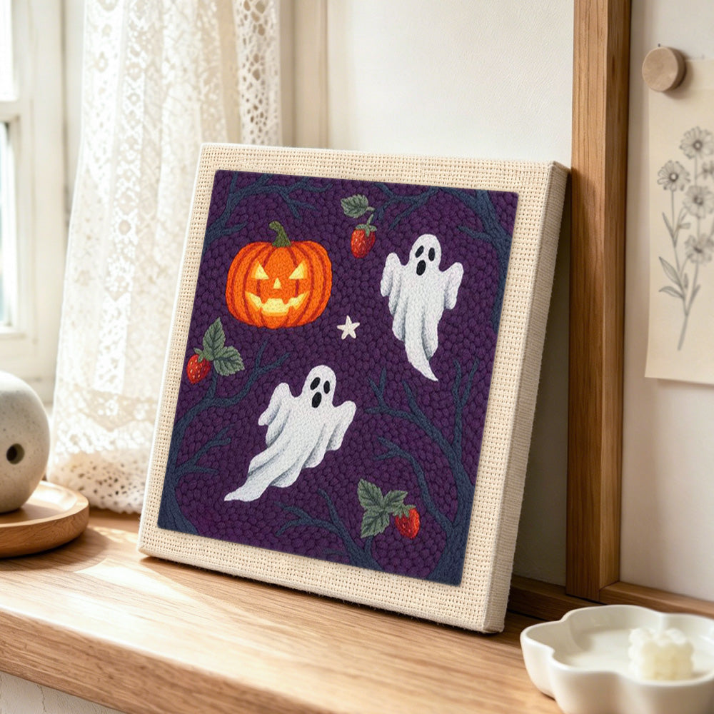 Ghosts and wild pumpkin punch needle artwork displayed on a table