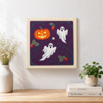 Finished ghosts and wild pumpkin artwork displayed on a wall
