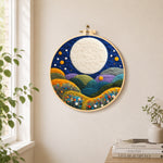 Giant white moon over colorful flower hills needle felt wall art displayed in a bright home interior