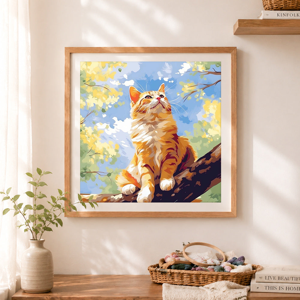 Finished ginger cat on tree branch cross stitch artwork displayed as home decor