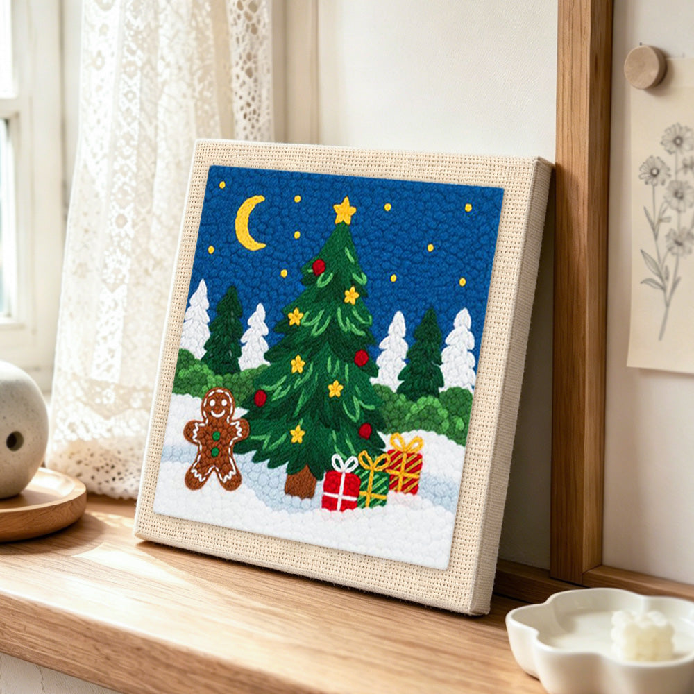 Gingerbread man and christmas tree punch needle artwork displayed on a table