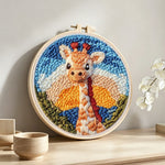 Giraffe at sunset punch needle artwork displayed on a table