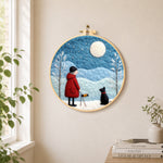 Girl in red coat walking black dog needle felt wall art displayed in a bright home interior