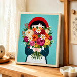 Girl in red headscarf holding flowers punch needle artwork displayed on a table