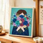 Girl with romantic flower bunch punch needle artwork displayed on a table