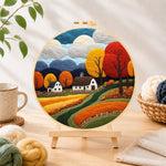 Finished golden autumn tree and rolling hills needle felting displayed on a wooden easel