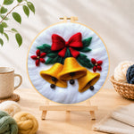 Finished golden christmas bells with red bow needle felting displayed on a wooden easel