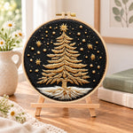Golden festive tree embroidery kit finished hoop displayed on a wooden stand as cozy tabletop decor