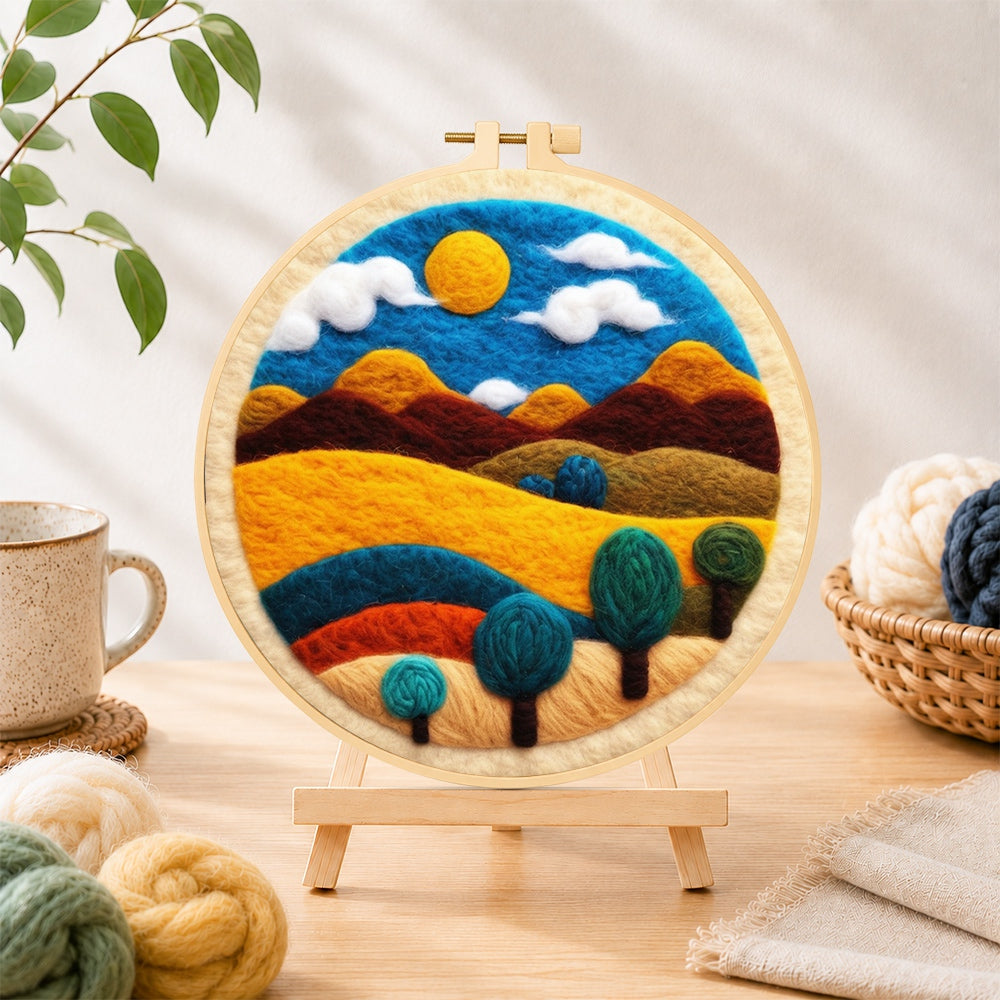 Finished golden sun and swirling tree hills needle felting displayed on a wooden easel