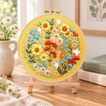 Golden sunflower wreath with white birds embroidery kit finished hoop displayed on a wooden stand as cozy tabletop decor