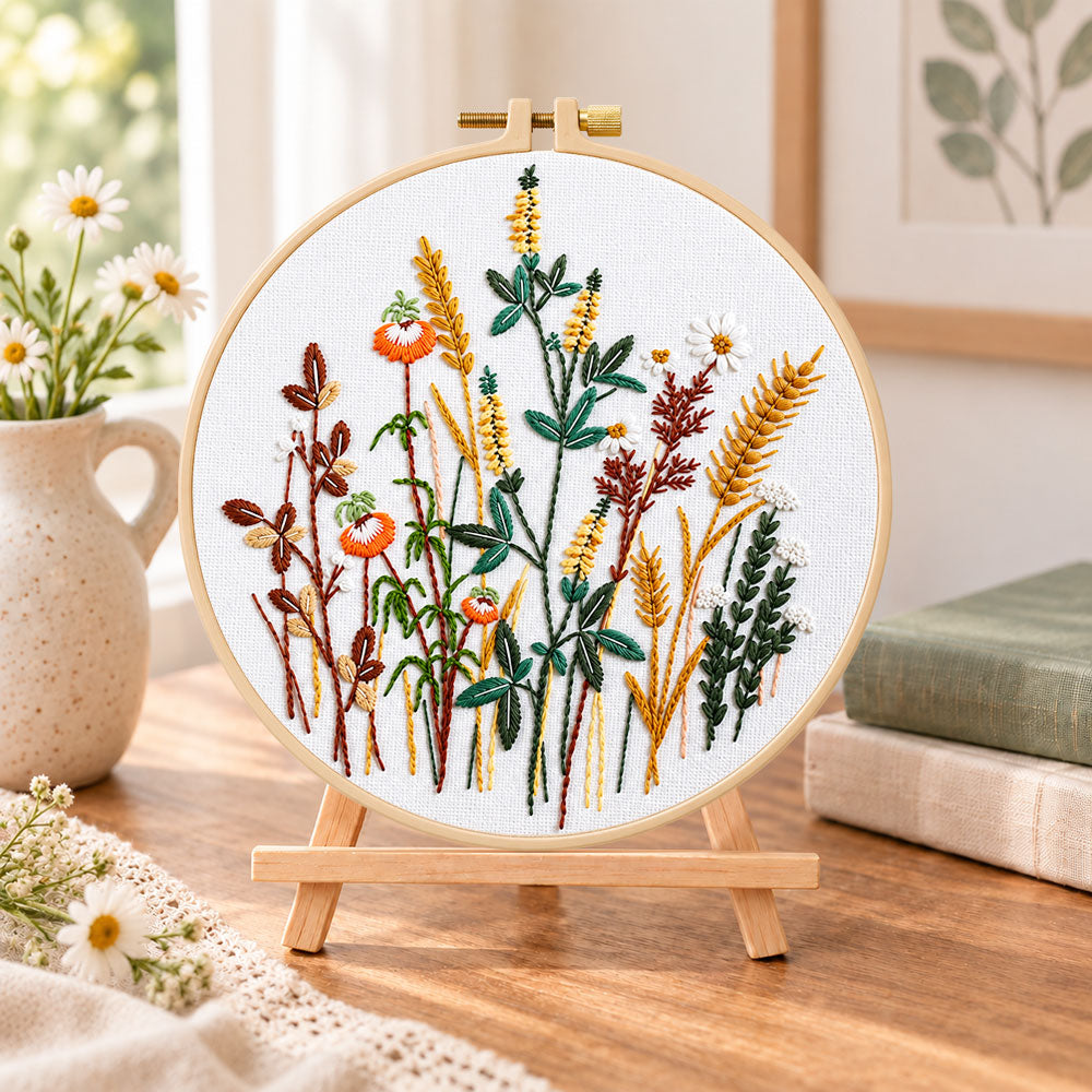 Golden wheat and poppy blooms embroidery kit finished hoop displayed on a wooden stand as cozy tabletop decor