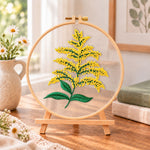 Goldenrod sprig embroidery kit finished hoop displayed on a wooden stand as cozy tabletop decor