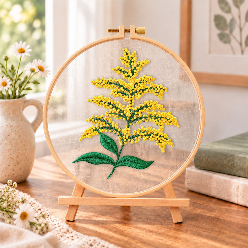 Goldenrod sprig embroidery kit finished hoop displayed on a wooden stand as cozy tabletop decor