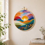 Gradient clouds, bright yellow sunset and colorful hills needle felt wall art displayed in a bright home interior