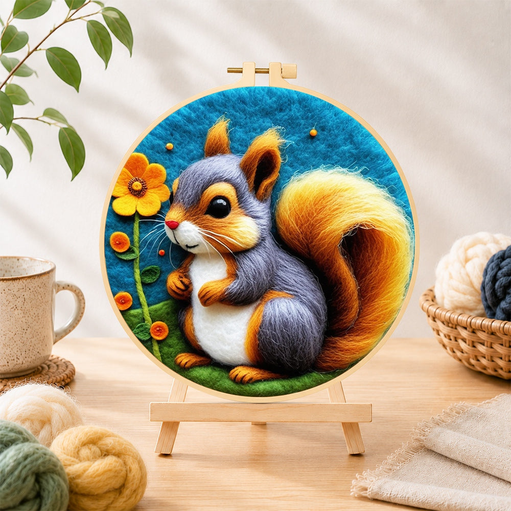 Finished gray and orange squirrel with golden tail needle felting displayed on a wooden easel