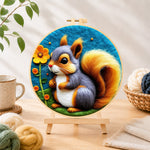 Finished gray and orange squirrel with golden tail needle felting displayed on a wooden easel