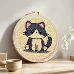 Gray kitten punch needle artwork displayed on a table
