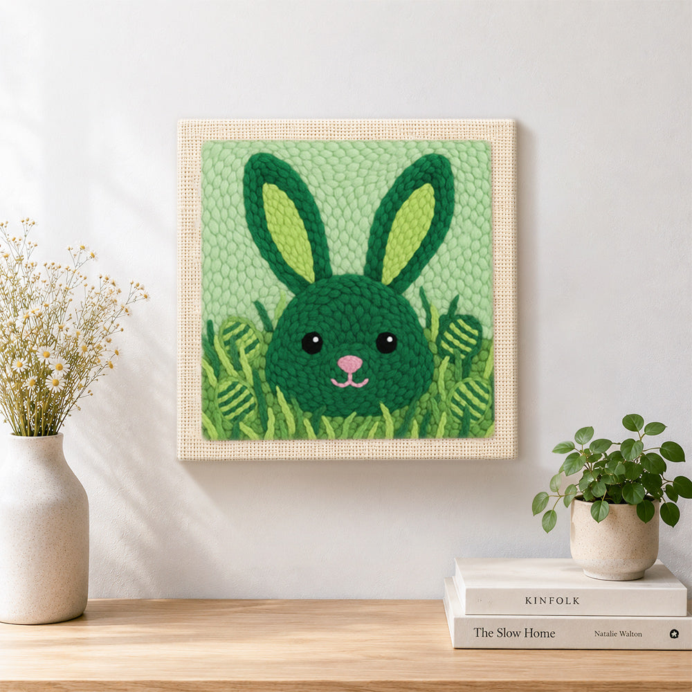 Finished green bunny hiding in grass artwork displayed on a wall