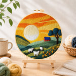 Finished green hills and fluffy sheep under golden sunset needle felting displayed on a wooden easel