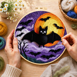Creating the halloween bats and spooky swirling clouds wool painting by hand with a felting needle