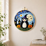 Halloween penguin in witch hat needle felt wall art displayed in a bright home interior