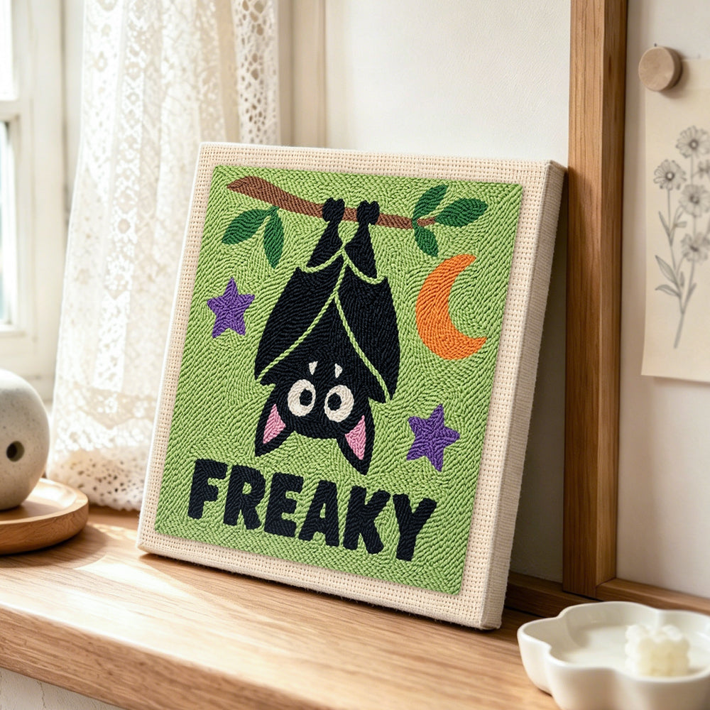 Hanging freaky bat punch needle artwork displayed on a table