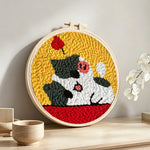 Happy and adorable cat punch needle artwork displayed on a table