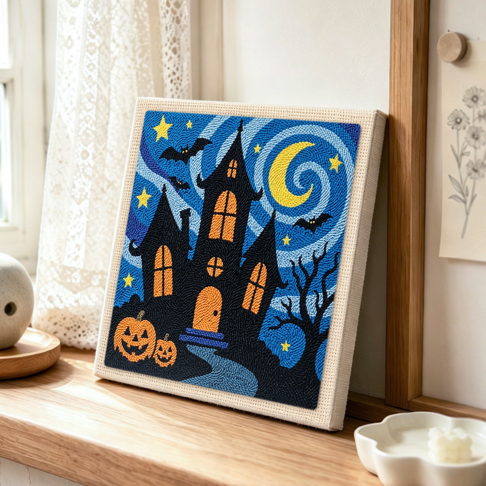 Haunted house night scene punch needle artwork displayed on a table