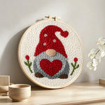 Heart-holding winter gnome punch needle artwork displayed on a table