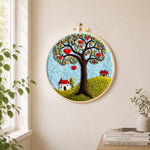 Heart tree and little houses needle felt wall art displayed in a bright home interior