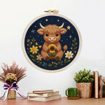 Finished highland cow and flowers at night artwork displayed on a wall