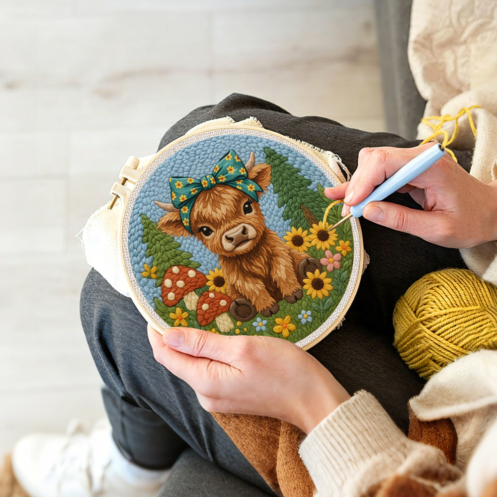 Creating handmade highland cow and mushrooms on the green grass punch needle artwork