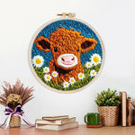 Finished highland cow and white daisies artwork displayed on a wall