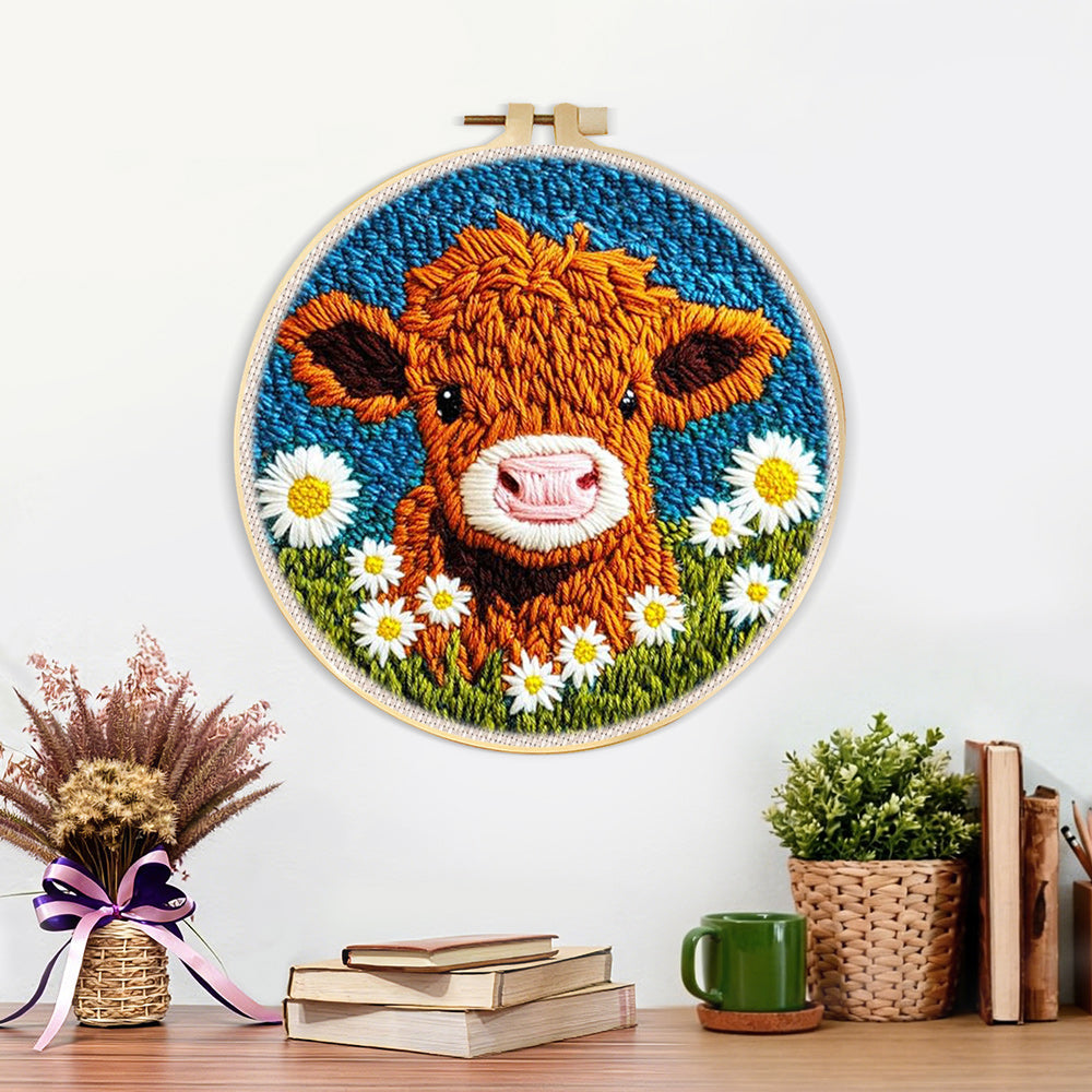 Finished highland cow and white daisies artwork displayed on a wall