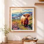 Finished highland cow by coastal cliff cross stitch artwork displayed as home decor