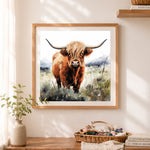Finished highland cow in scottish landscape cross stitch artwork displayed as home decor